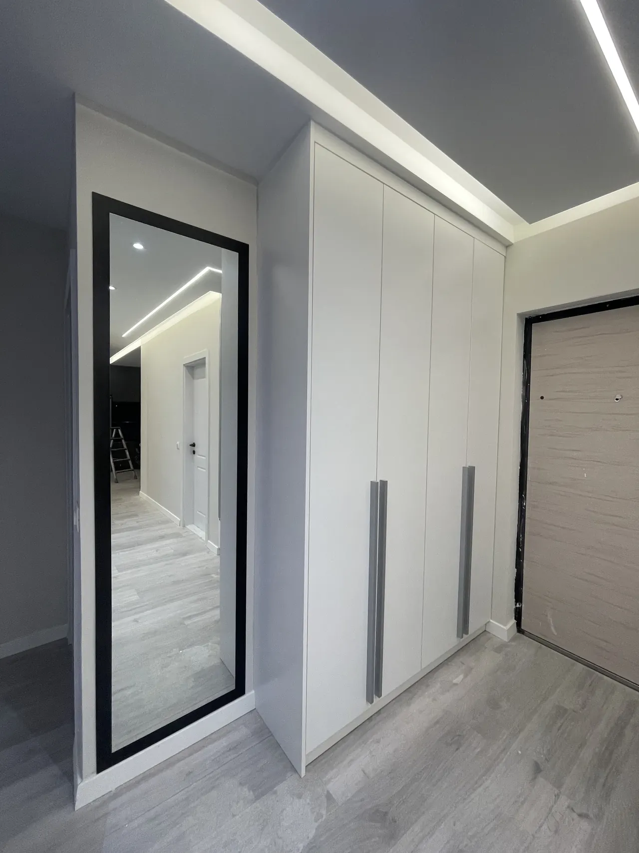 Weißer Einbauschrank im Flur mit großem Wandspiegel
