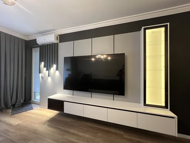 TV-Wand mit Wandpaneelen, hängendem Lowboard und beleuchteter Vitrine