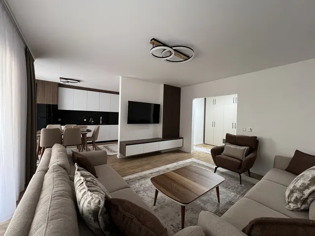 Offener Wohnbereich mit Sofa, TV-Wand und Essbereich